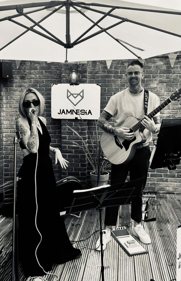 Vix and DS performing in front of a Jamnesia fox sign